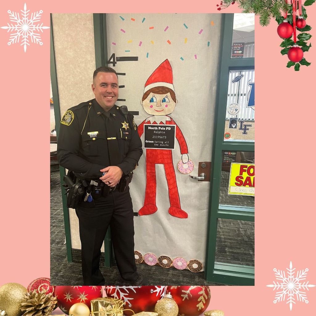 Officer Meeks beside a door with an elf who has been naughty