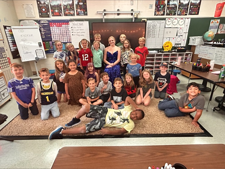 girl in dress posing with second graders