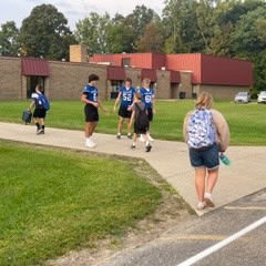 football players greeting students