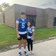 football player posing with student