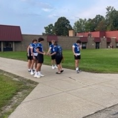 football players greeting students