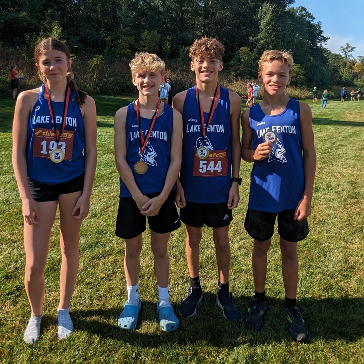 4 cross country runners wearing medals 