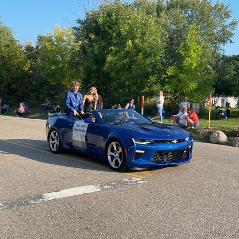 homecoming court riding in blue convertible 
