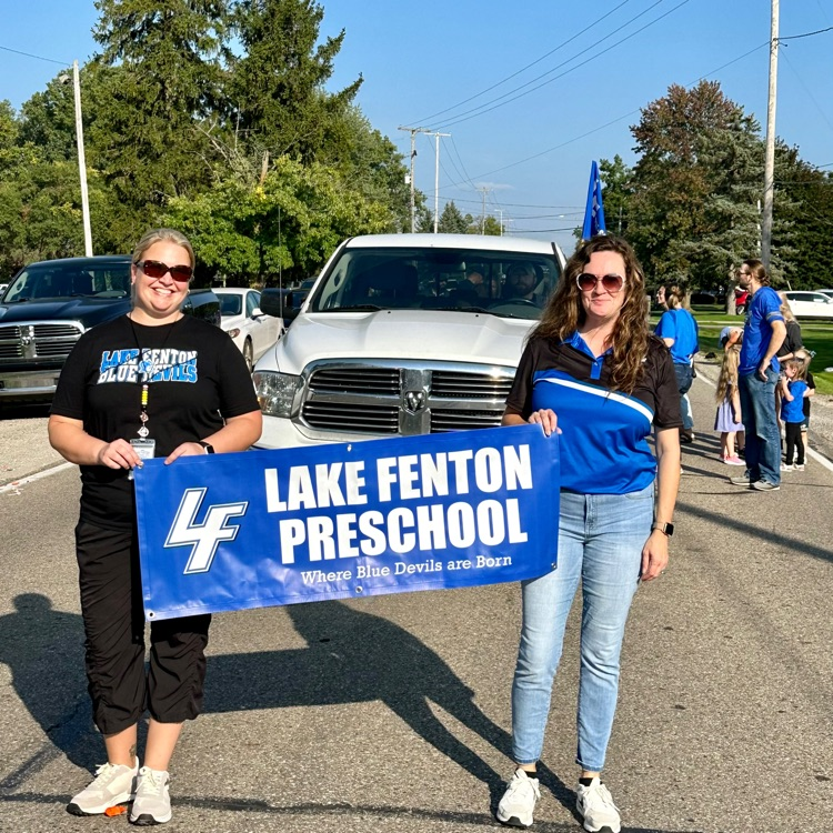 2 women holding preschool sign