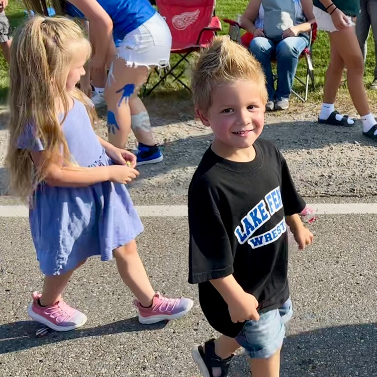 2 little kids walking in parade